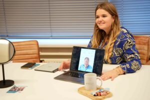 Lieselotte laat foto's op laptop zien van FUE haartransplantatie aan cliënt.